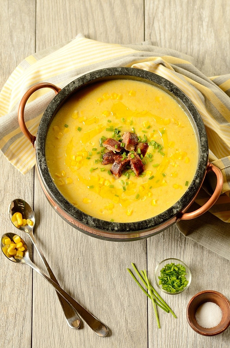 Brazilian corn chowder over table with garnishes