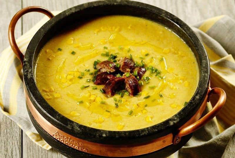 a pot of corn chowder with chopped sausage on top as one of the 70 easy one pot meals