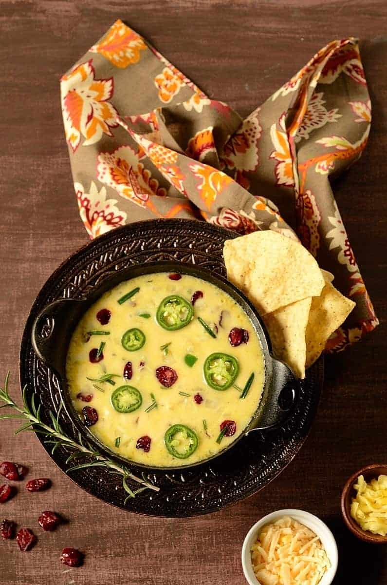 An ooey-gooey, salty-sweet and mildly spicy Cranberry Jalapeno Queso Fundido Dip to serve as an easy appetizer for the holidays. It's low carb, keto, and gluten-free! queso fundido with tortilla chips on the side