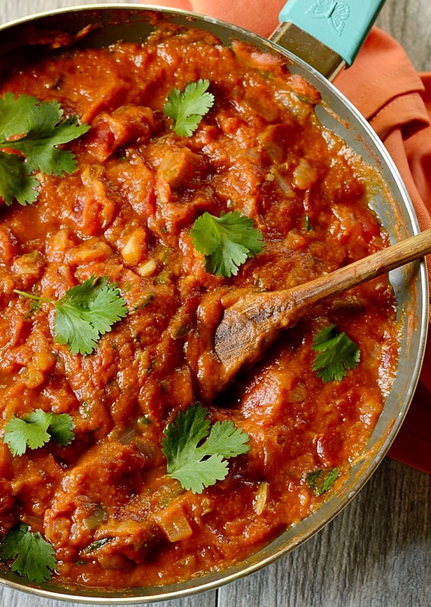 pumpkin jalapeno salsa in a pan with wooden spoon on the side