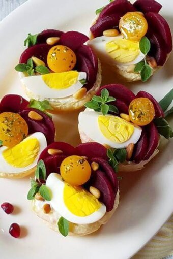 A plate with puffy pastry tartlets garnished for the holidays