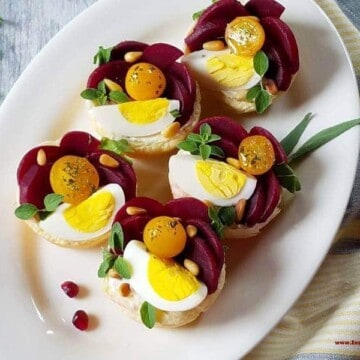 A plate with puffy pastry tartlets garnished for the holidays