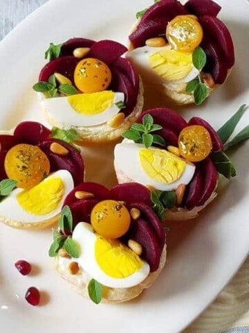 A plate with puffy pastry tartlets garnished for the holidays