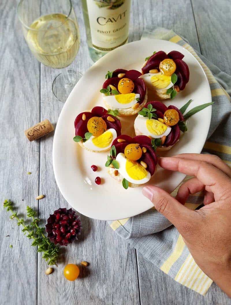 A hand picking up a an appetizer that is resting in a plate