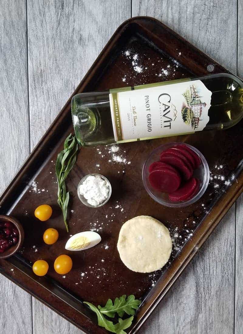 A baking sheet with a bottle of wine and ingredients for the recipe