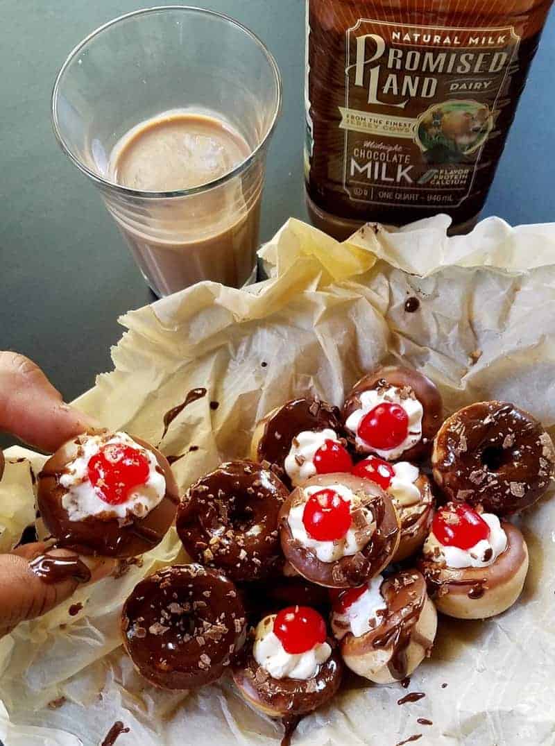 a hand picking up a donut