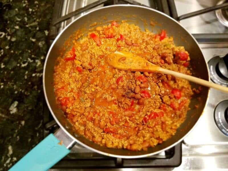 A pan with ground turkey and beans being cooked on the stovetop