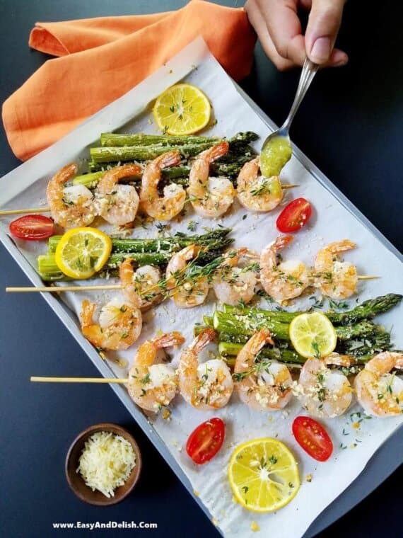 drizzling sauce over baked shrimp and asparagus