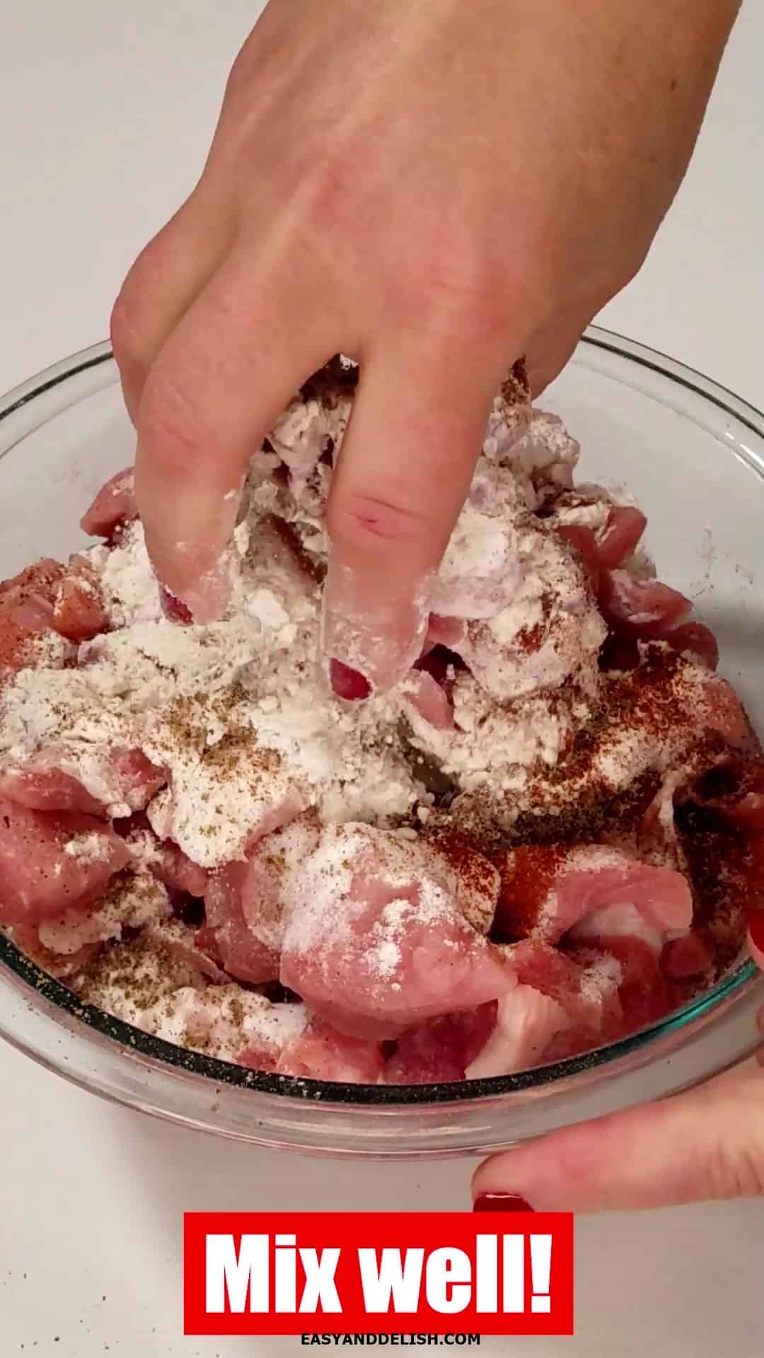 Mixing flour and seasonings with the meat in a bowl. 