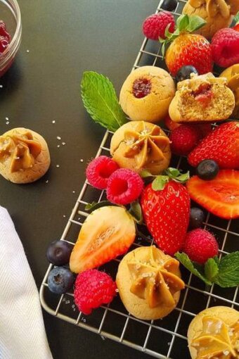 A rack of peanut butter and jelly cookies and berries