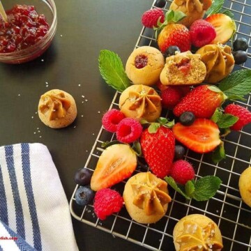 A rack of peanut butter and jelly cookies and berries