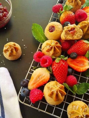 A rack of peanut butter and jelly cookies and berries