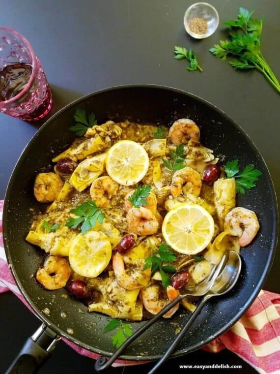 one pot seafood in pesto sauce served with garnishes on the side
