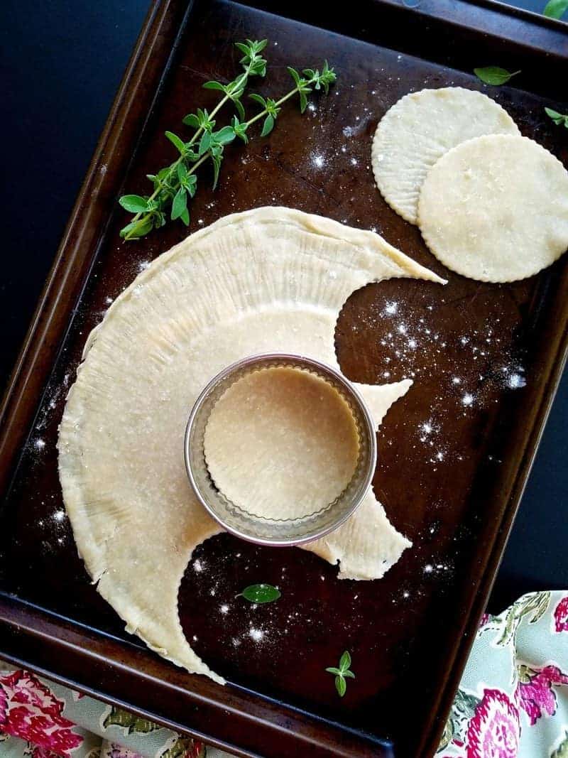 empanada dough being cut with a cookie cutter