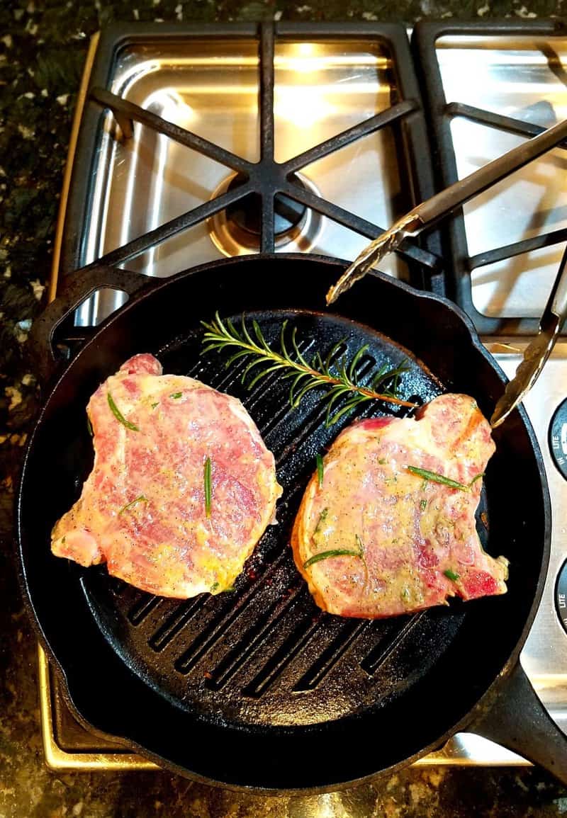 image showing pork chops being grilled in a skillet