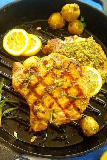 A pan of grilled pork chops with Chimichurri plus mini potatoes