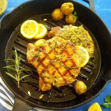 A pan of grilled pork chops with Chimichurri plus mini potatoes