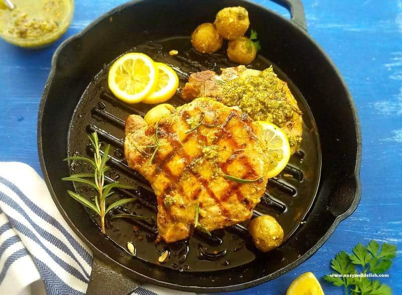 A pan of grilled pork chops with Chimichurri plus mini potatoes