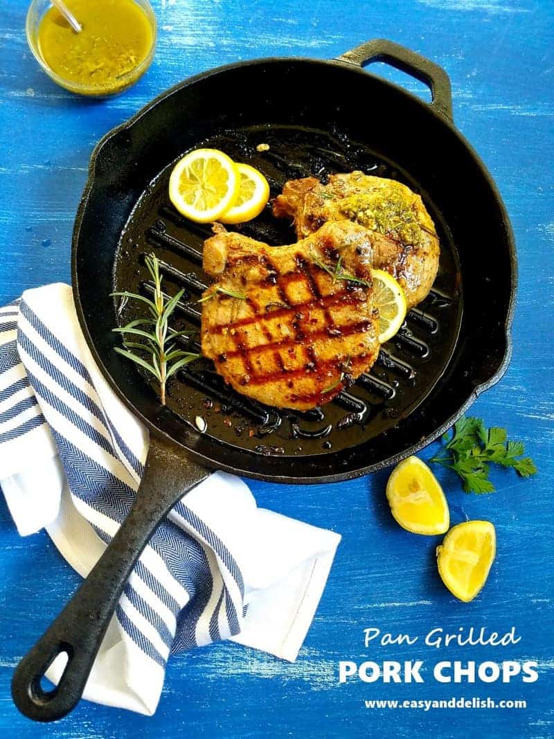 grilled pork chops with Chimichurri and lemon wedges on a table