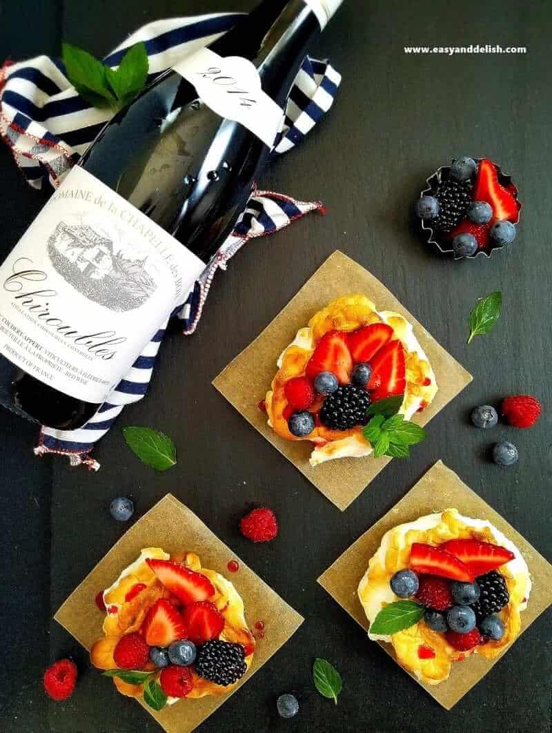 a bottle of wine and 3 cloud eggs with berries