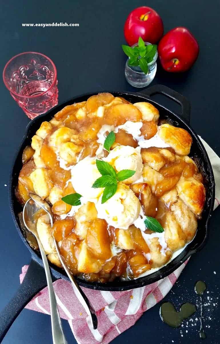 slated caramel apple cobbler in a skillet topped with ice cream