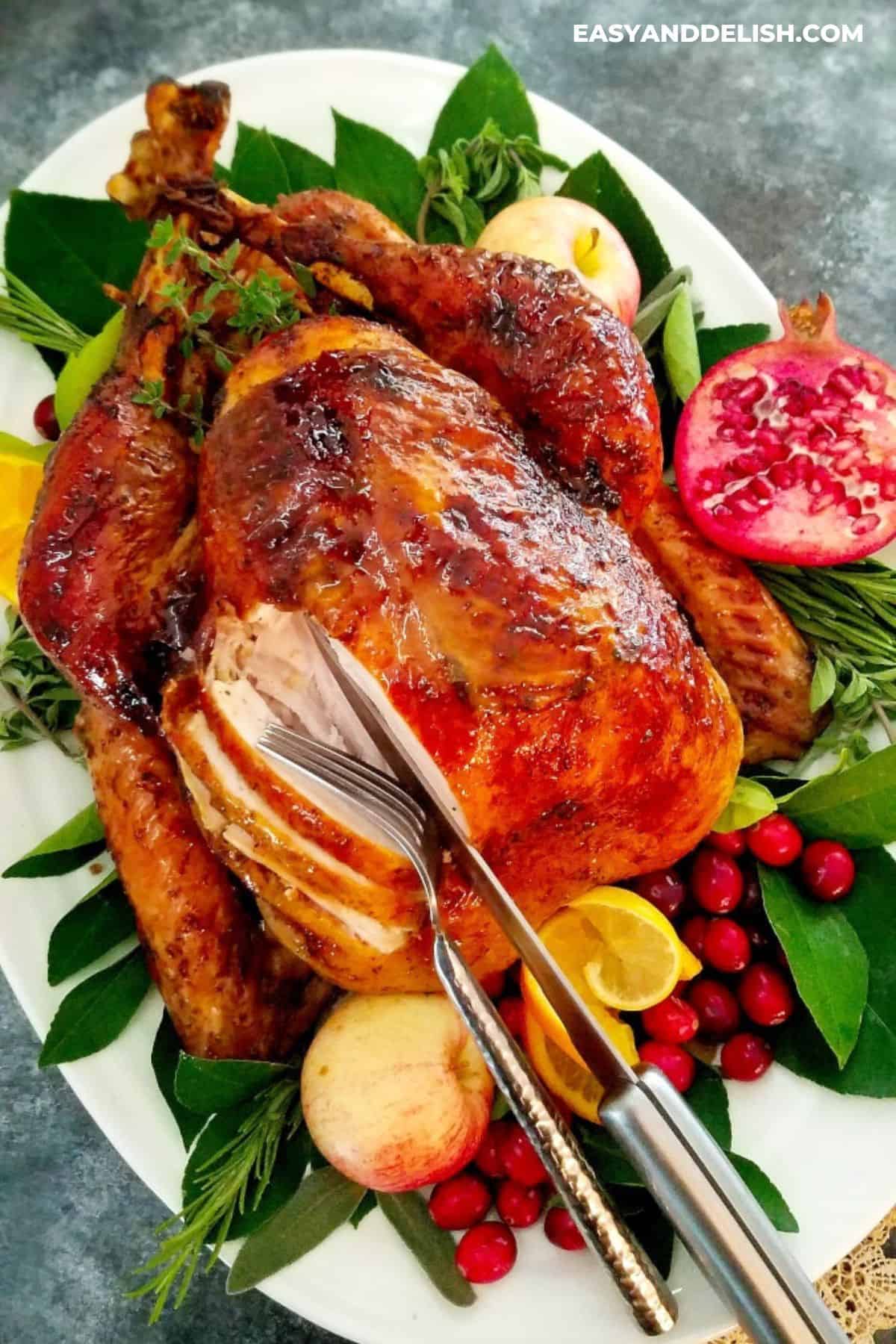 Roast poultry in a platter with breast partially sliced.