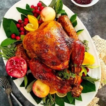 High angle photo of a whole, brined turkey on a white platter