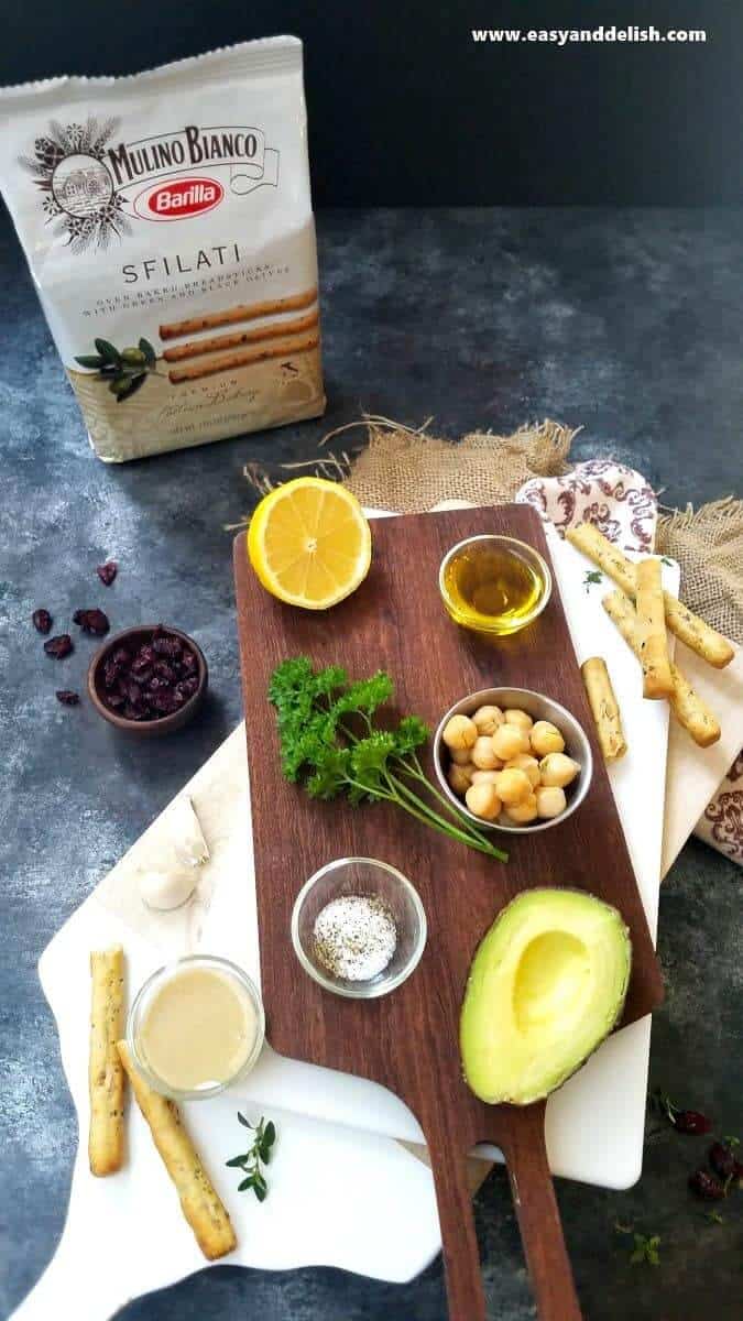 Avocado Hummus Recipe is a no cooking, quick and easy appetizer made with a few simple ingredients, and served with olive breadsticks. It’s perfect for the Holidays! ingreidents for avocado hummus recipe over a table