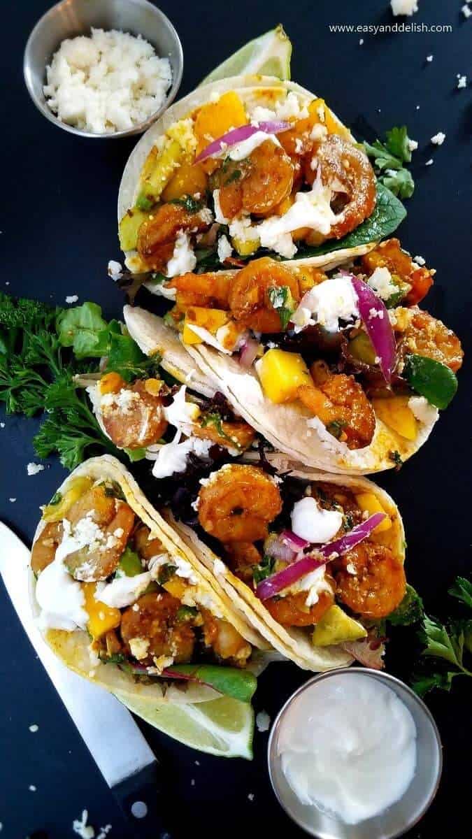 Close up image of lined up Mexican food with mango avocado salsa