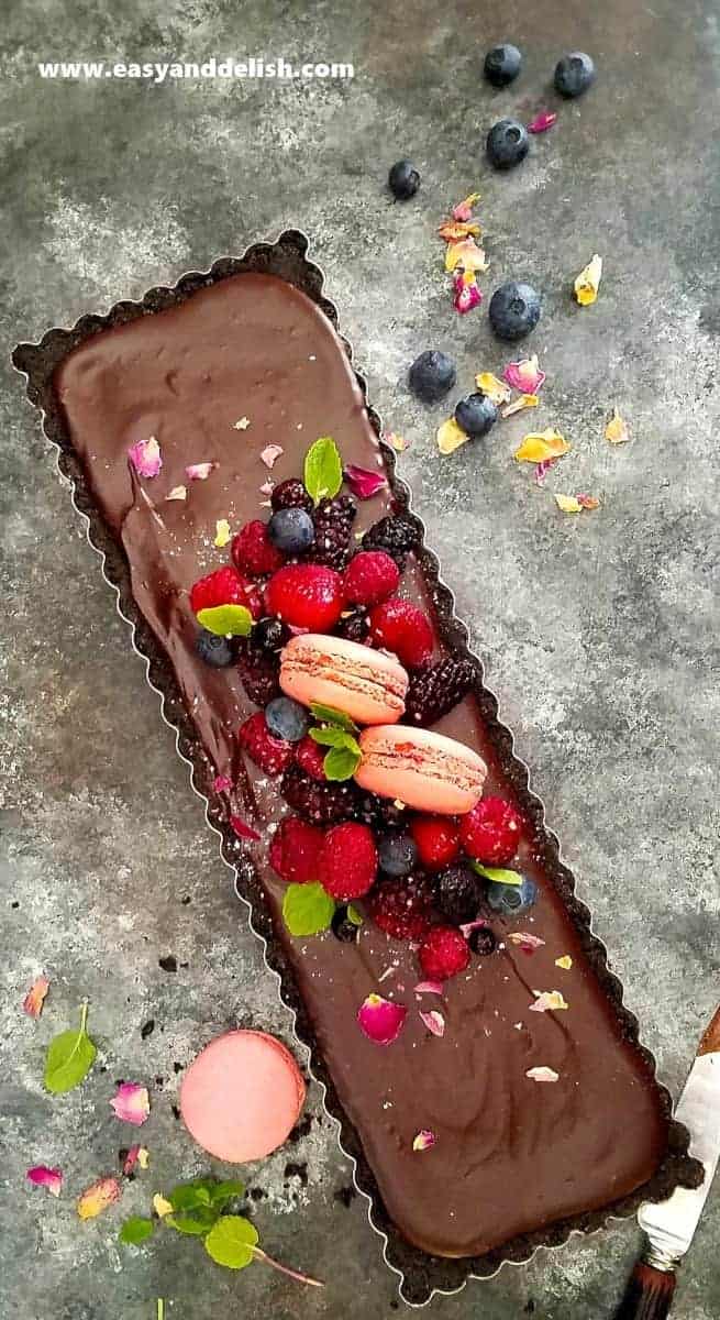 Overhead view of a whole No Bake Nutella Tart garnished with berries and macaroons in between berries