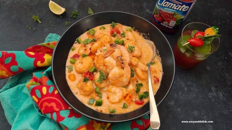 black bowl filled with shrimp and coconut stew with a spoon in it