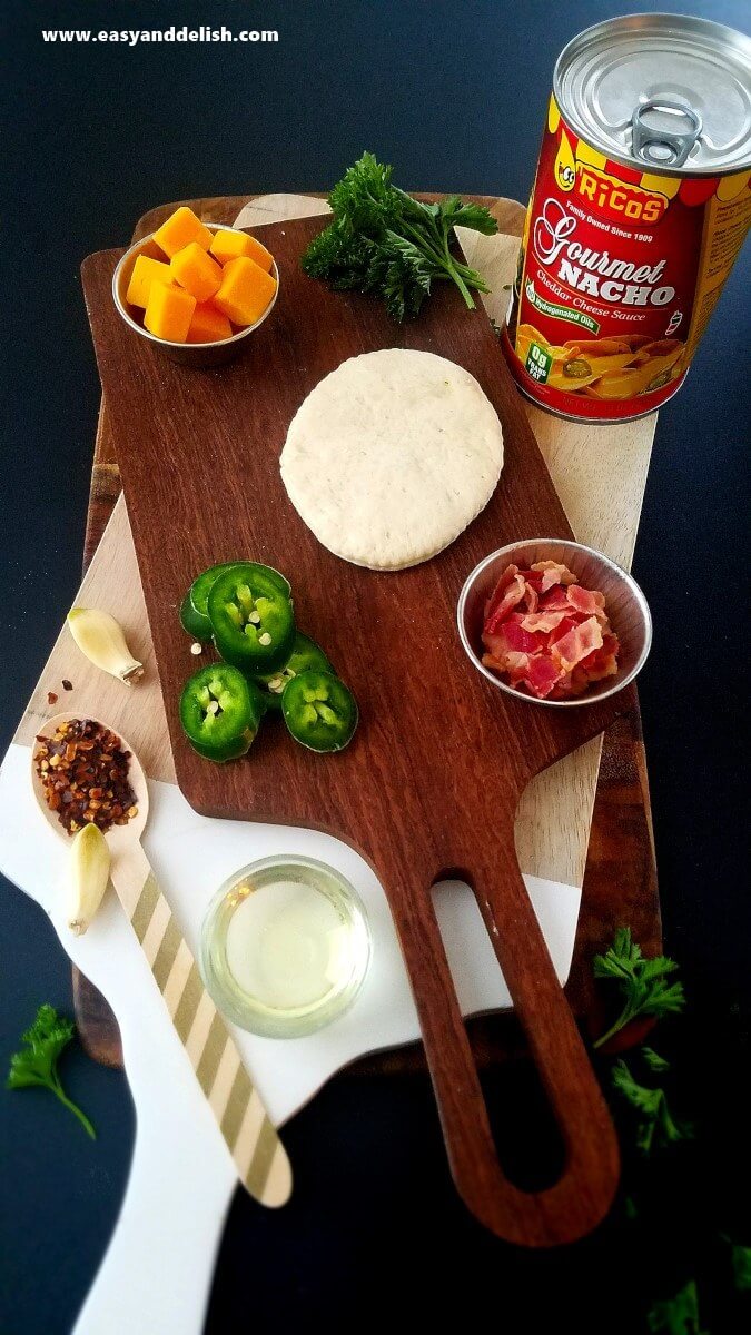 Image displaying ingredients of nacho pizza bombs over cutting board. 