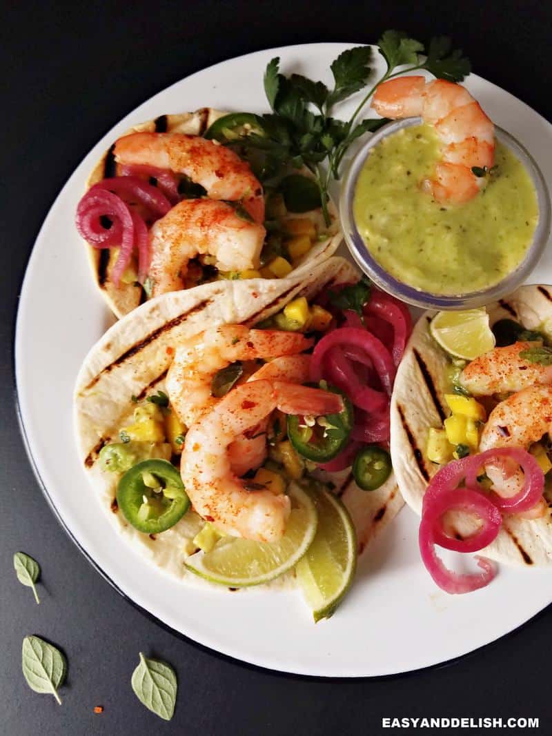 spicy shrimp tacos in a plate with side