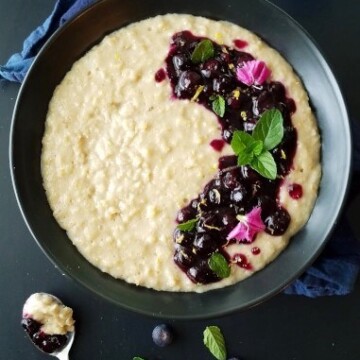 a bowl of oatmeal with blueberries and flowers