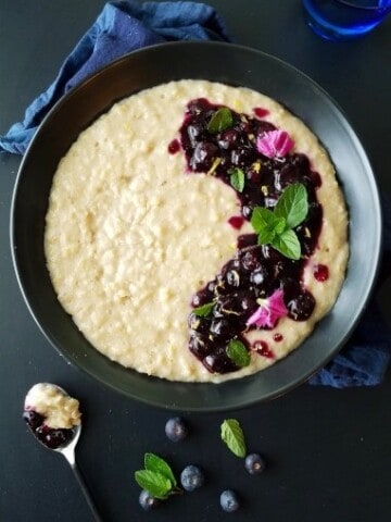 a bowl of oatmeal with blueberries and flowers