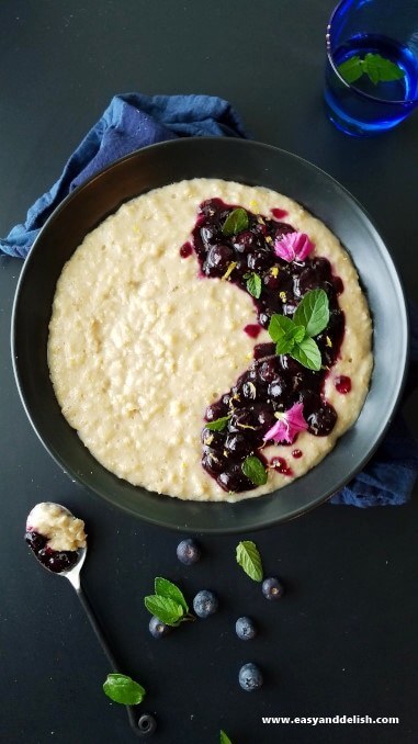 a bowl of oatmeal with blueberries and flowers