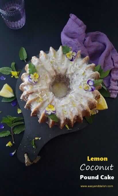 Overhead view of lemon coconut pound cake with garnishes on the side and a cup of water at the background. 