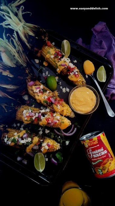 Several ears of Nacho corn on the cob on a baking sheet.