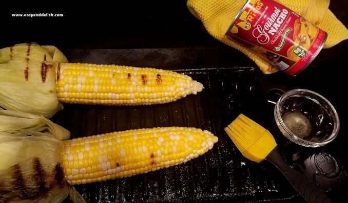 Two ears of corn on the cob on a grilling pan