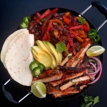 close up of pork fajitas with tortillas on the side