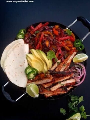 close up of pork fajitas with tortillas on the side