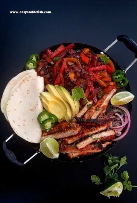 close up of pork fajitas with tortillas on the side