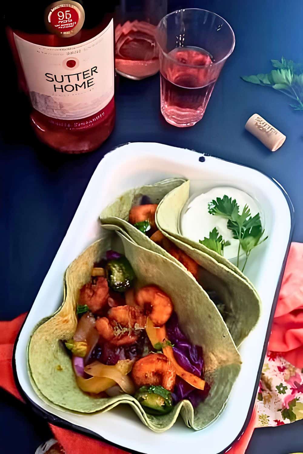 Spicy shrimp fajitas served in tortillas with a bottle of wine at the background.