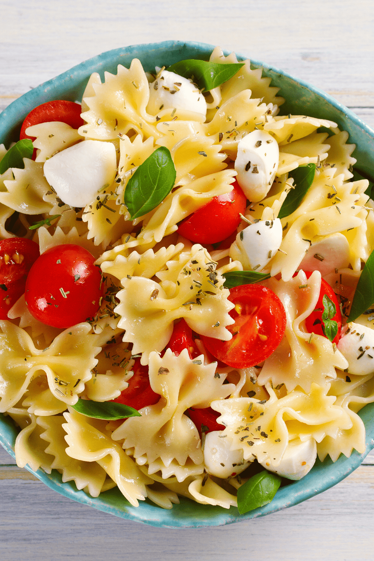 close up of a bowl with caprese pasta salad with balsamic dressing.
