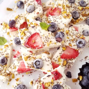 many pieces of the Frozen yogurt bark on parchment paper.