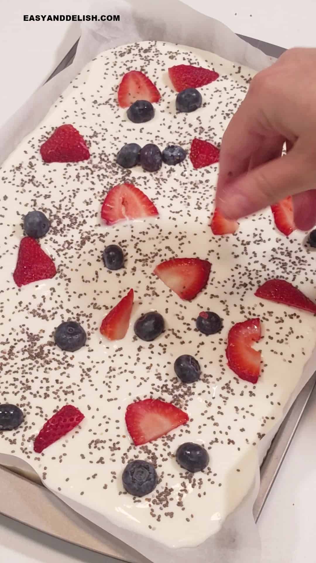 topping yogurt mixture with chia seeds and berries. 