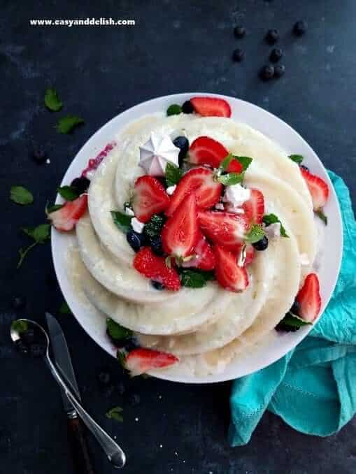 Bolo de tapioca, also known as tapioca cake,  with coconut and strawberry topping on a plate