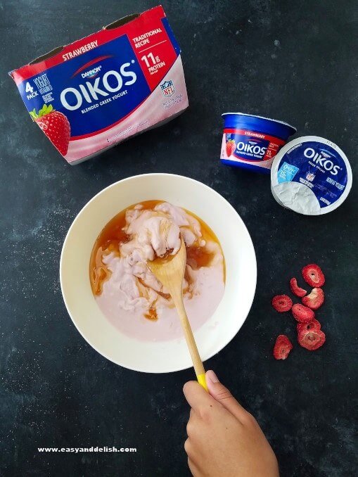 Yogurt and honey being mixed in a bowl