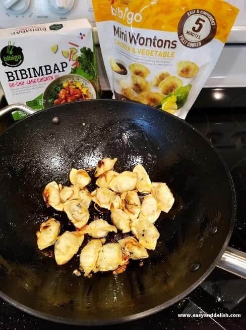 wontons being cooked in a wok