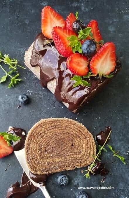 chocolate cake roll topped with berries and partially sliced